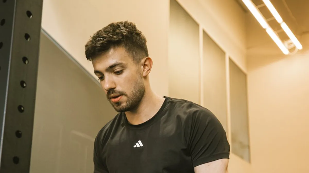 Trener personalny Jan Tekieli przy poręczach w kameralnym studiu treningowym w Krakowie