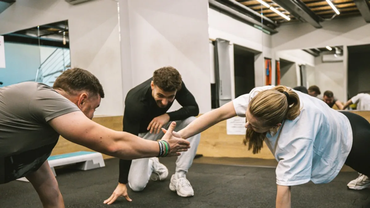 Trener Jan Tekieli prowadzi trening personalny pary w studiu treningowym w Krakowie
